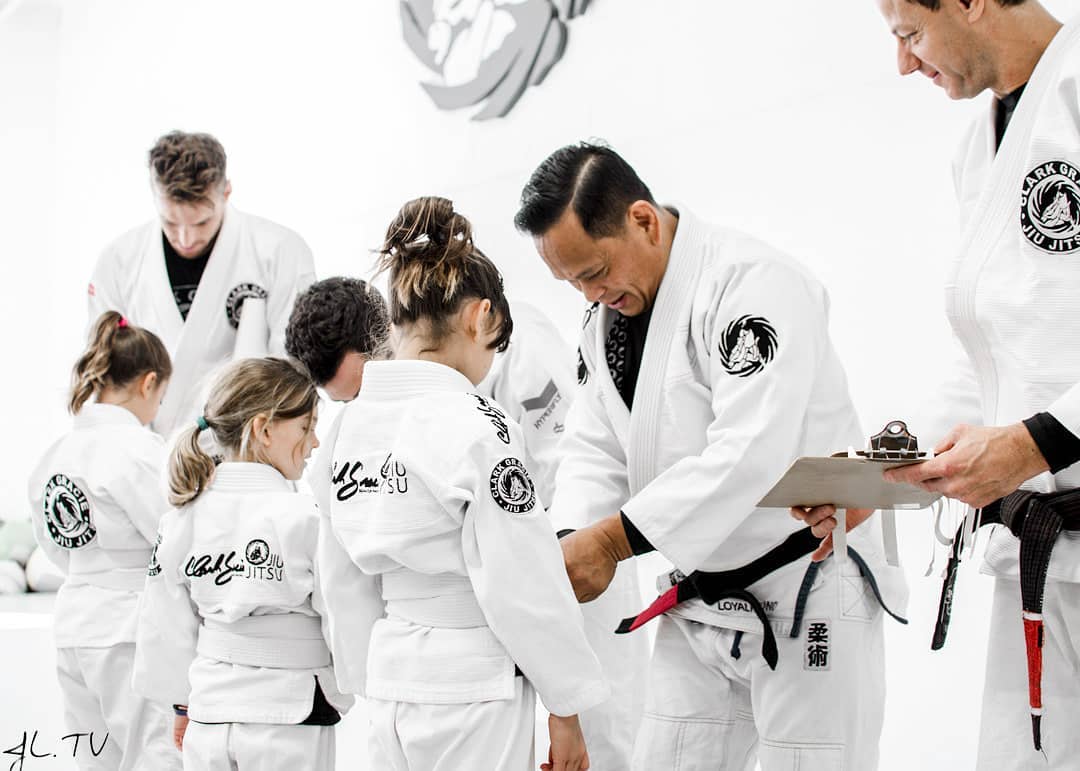 Child jiu-jitsu practictioner receiving belt promotion