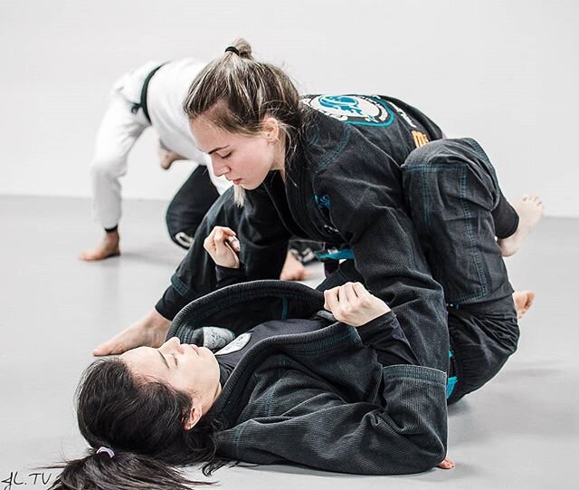 Women Jiu Jitsu practioners grappling on the mat